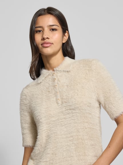 Frauenmodel trägt Strickpullover mit 1/2-Arm und Knopfleiste von Christian Berg Woman, cremefarben, strukturierte Textur, Nahaufnahme Oberkörper.