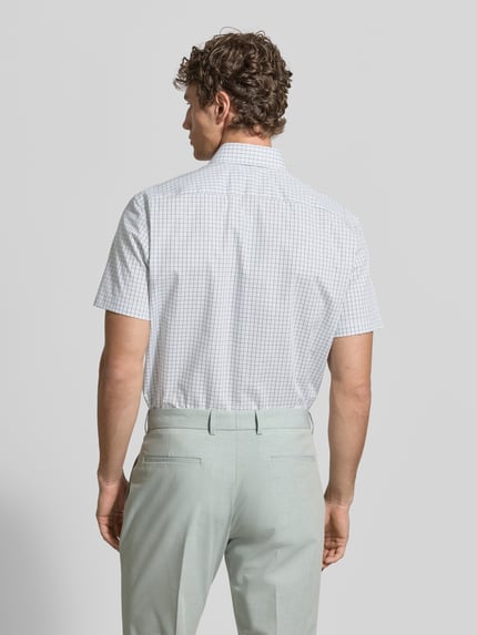 Męski model nosi Regular Fit Business-Hemd aus Baumwolle mit Kentkragen od Christian Berg Men, biała koszula w kratę, krótki rękaw, krój regular fit, czysta bawełna, szerokość w rozmiarze 39/40: 44 cm, długość tyłu: 77 cm, długość rękawa: 23 cm, widok całej sylwetki z tyłu