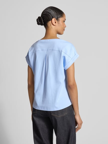 Kobiece model prezentuje damski t-shirt z bawełny o kroju regular fit, okrągły dekolt, rękawy z zakładką, długość tyłu 59 cm w rozmiarze 36, t-shirt mit rundhalsausschnitt marki monari, widok całej sylwetki z tyłu.