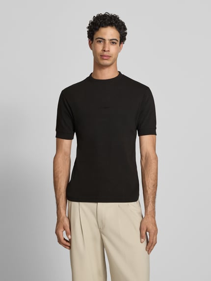 Männermodel trägt Slim Fit T-Shirt mit Label-Stitching von PROHIBITED aus Baumwoll-Elasthan-Mix, Rundhalsausschnitt, Herren T-Shirt, Rückenlänge 65 cm, Größe M, einfarbig, Ganzkörperansicht von vorne.