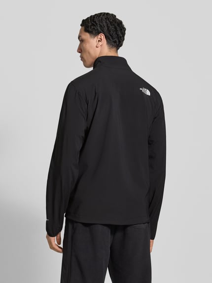 Männermodel trägt schwarze Jacke mit Stehkragen und Logo von The North Face, Material-Mix mit Stretch, Ganzkörperansicht Rückansicht.