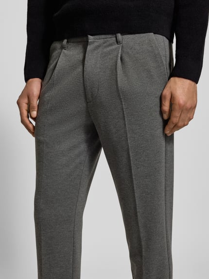 Männermodel trägt Regular Fit Bundfaltenhose mit Viskose-Anteil von Marc O'Polo Denim, unifarben, tunnelzug, zijzakken, nahaufnahme oberkörper.