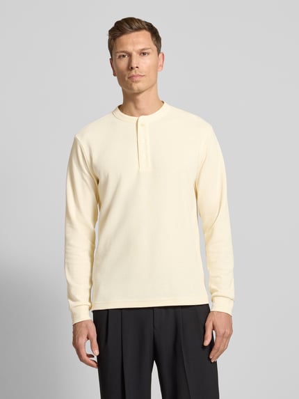 Männermodel trägt Regular Fit Pullover mit Knopfleiste Modell 'Kilano' von Drykorn in Creme, Strukturmuster, Rundhalsausschnitt, Ganzkörperansicht von vorne. Baumwoll-Mix, Rückenlänge 70 cm bei Größe M.