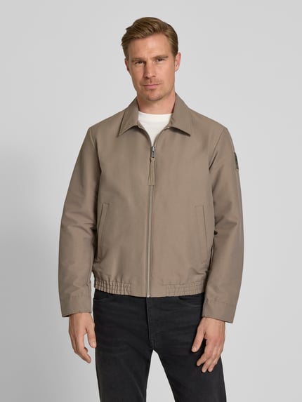 Männermodel trägt Regular Fit Blouson mit Label Patch - Marc O'Polo × DFB Travel Collection, Optik: Unifarben, Ganzkörperansicht von vorne.