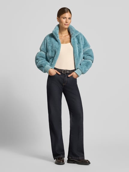Frauenmodel trägt Longsleeve in Ripp-Optik Modell 'COLETTE' von GUESS Activewear, Beige, Slim Fit, Rundhalsausschnitt, Ganzkörperansicht von vorne. Viskose-Elasthan-Mix, Label-Detail, Rückenlänge 54 cm bei Größe S.