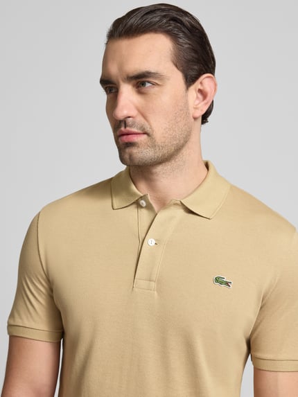 Männermodel trägt Slim Fit Poloshirt aus reiner Baumwolle von Lacoste, Optik: Unifarben, Logo-Stitching, Polokragen, Kurzarm, Materialverarbeitung: Piqué, Nahaufnahme Oberkörper.
