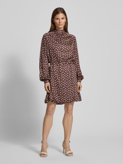 Vrouwenmodel draagt Cocktailkleid met Stehkragen van Rinascimento, bruine viscose met lichte vlekken, tailleriem, geheel vooraanzicht.