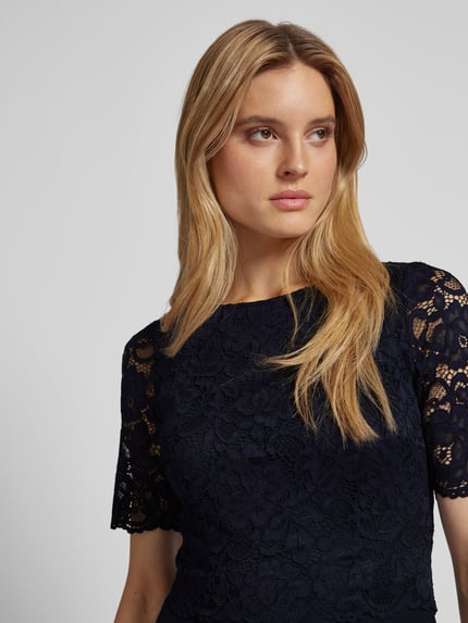 Frauenmodel trägt Cocktailkleid mit Spitzenbesatz von Vera Mont, Unifarbenes-Design, Material-Mix mit Stretch-Anteil, Nahaufnahme Oberkörper.