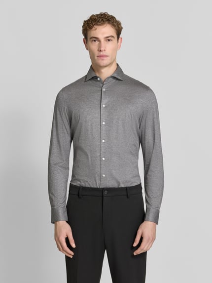 Männermodel trägt Slim Fit Businesshemd aus Baumwoll-Modal-Mix Modell 'Light Spread Kent' von Seidensticker in Grau mit Struktur, Ganzkörperansicht von vorne.