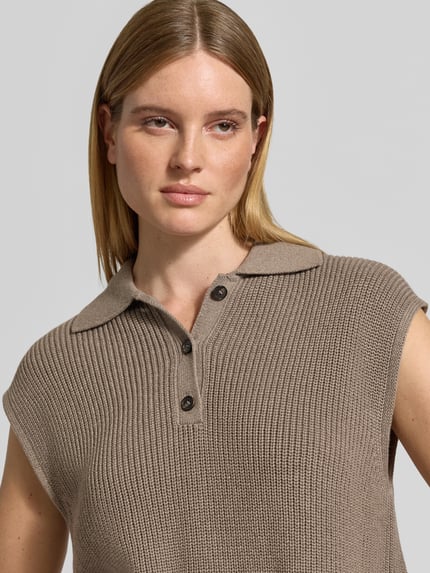 Frauenmodel trägt Regular Fit Strickpullunder mit Polokragen von MARC O'POLO in melierter Strickoptik mit Knopfleiste, Nahaufnahme Oberkörper.