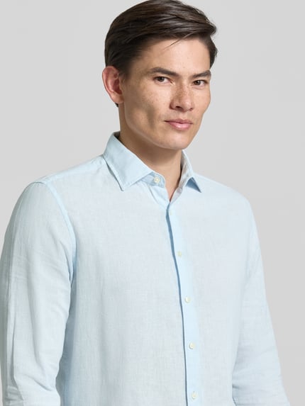 Männermodel trägt Slim Fit Freizeithemd aus Leinen-Mix Modell 'Steven' von CINQUE in Hellblau, Baumwoll-Leinen-Mix, Kentkragen, Langärmelig, durchgehende Knopfleiste, Rückenlänge 68 cm, Schulterbreite 42 cm, Ärmellänge 65 cm, Nahaufnahme Oberkörper.