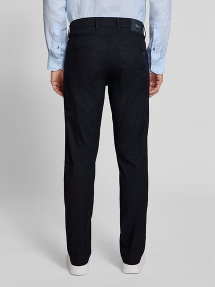 Mannenmodel draagt Regular Fit Stoffhose aus Baumwoll-Leinen-Mix Modell 'CADIZ' van Brax in effen zwart met label patch, vijf zakken, knoopsluiting, katoenen-linnenmix, achteraanzicht hele lichaam.