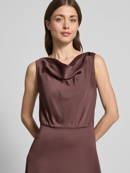 Frauenmodel trägt Cocktailkleid mit Wasserfall-Ausschnitt von Swing aus Satin in A-Linie, Midikleid, strukturierte Textur, Nahaufnahme Oberkörper.