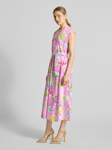 Vrouwenmodel draagt Midikleid mit V-Ausschnitt und Bindegürtel van Milano Italy, roze met kleurrijke bloemenprint, A-lijn, puur katoen, allover-look, V-hals, ceintuur, ruglengte maat 36: 127 cm, borstwijdte maat 36: 50 cm, volledig zicht schuin van voren.