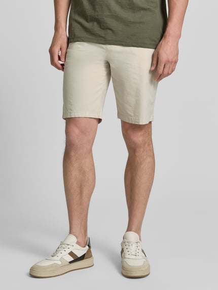 Männermodel trägt Tapered Chinoshorts aus Baumwoll-Mix Modell 'CHINO_TAPERED_DS_3S' von BOSS Orange, Optik: Unifarben, Nahaufnahme Oberschenkel