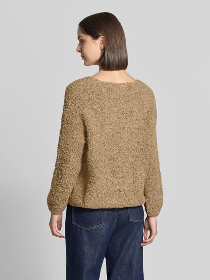 Frauenmodel trägt Relaxed Fit Strickjacke aus Woll-Viskose-Mix Modell 'Sofia' von ZABAIONE in Hellbraun, grobe Textur, Ganzkörperansicht Rückansicht, Damen Strickjacke, langer Arm, V-Ausschnitt, durchgehende Knopfleiste, Rückenlänge 62 cm, Ärmellänge 45 cm.
