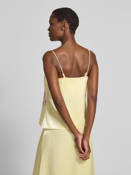 Frauenmodel trägt Trägertop aus Satin Modell 'ORCHIDA' von YAS in Gelb mit Motiv-Print, Regular-Fit, Rückenlänge 59 cm bei Größe 36, Ganzkörperansicht Rückansicht.