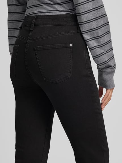 Frauenmodel trägt High Waist Jeans Wide Fit mit Dark Wash Modell 'Dream Kick' von MAC, unifarbener Denim, 5-Pocket-Design, Nahaufnahme Rückansicht.