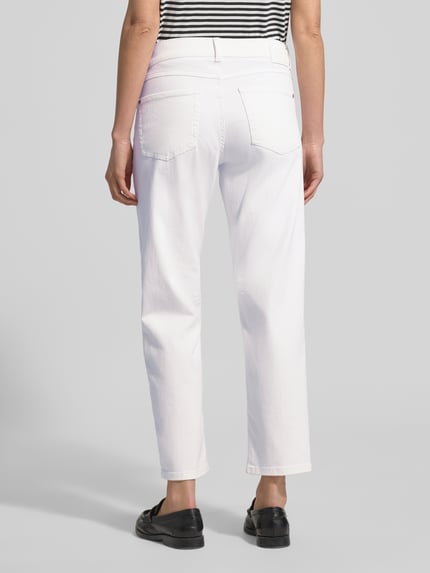Frauenmodel trägt Jeans mit Eingrifftaschen Modell 'Evy' von Angels, weißer Baumwoll-Mix mit Stretch-Anteil, Regular-Fit, Ganzkörperansicht Rückansicht. Bundweite bei Größe 36: 41 cm, Innenbeinlänge 71 cm.
