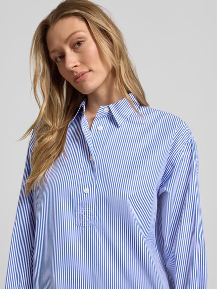 Frauenmodel trägt Oversized Hemdblusenkleid aus reiner Baumwolle von Lauren Ralph Lauren mit blau-weißem Streifenmuster, Twillgewebe, Knopfleiste, hochgeschlossen, Nahaufnahme Oberkörper.