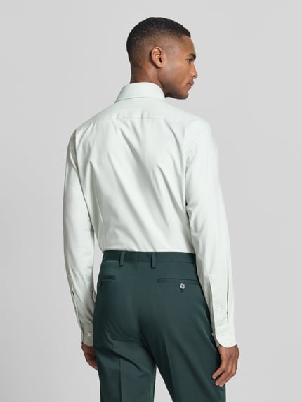 Männermodel trägt Regular Fit Business-Hemd mit Kentkragen von OLYMP aus Baumwoll-Mix mit Stretch-Anteil, Ganzkörperansicht Rückansicht.