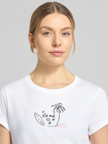 Modelka nosi T-Shirt mit Label-Print Modell 'DEBRA4' von FIRE + ICE, czysta bawełna, krój regular fit, dekolt okrągły, długość tyłu w rozmiarze S 58 cm, białe, nadruk z czarnym i różowym, zbliżenie na górną część ciała