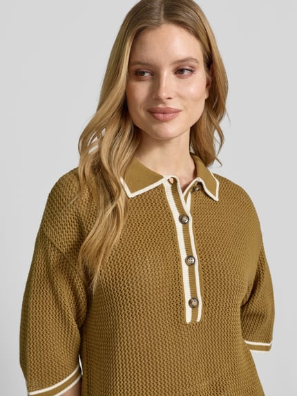 Frauenmodel trägt Strickshirt mit Polokragen und Knopfleiste von Style Icon Collection in Olivgrün, grob gestrickt, reine Baumwolle, Nahaufnahme Oberkörper.