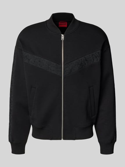 Frauenmodel trägt Oversized Sweatjacke aus Baumwoll-Mix Modell 'DROMZIP' von HUGO, Optik: Unifarben schwarz, Reißverschluss, Logo-Patch, Motiv-Stitching, College-Kragen, Langarm, gerippte Abschlüsse, seitliche Eingrifftaschen, Materialverarbeitung: Sweat, Ganzkörperansicht von vorne.
