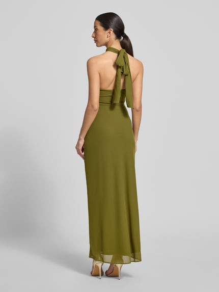 Vrouwenmodel draagt nauw aansluitende maxi-jurk met halter en cut-out, draperingen, model 'Jayni Halter Hardware' van Forever New, ruglengte maat 36 20 cm, borstwijdte maat 36 35 cm, olijfgroen, gladde textuur, geheel lichaam achteraanzicht.