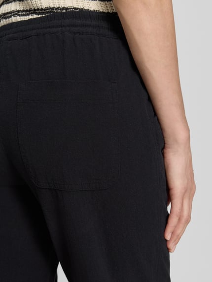 Frauenmodel trägt Hose mit elastischem Bund und Tunnelzug Modell 'Cissie' von Soyaconcept aus Reine Baumwolle, Relaxed-Fit, Detailaufnahme Rückansicht.
