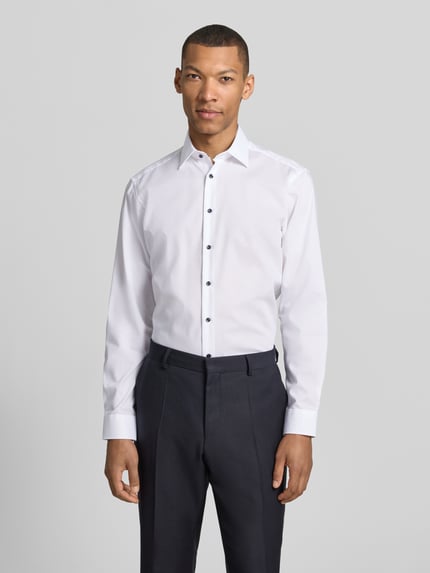 Männermodel trägt Regular Fit Business-Hemd mit Kentkragen von Christian Berg Men aus Reine Baumwolle, Ganzkörperansicht von vorne. Rücklänge 78 cm, Schulterbreite 47 cm, Ärmellänge 65 cm, Knopfleiste, Sportmanschetten, abgerundeter Saum.