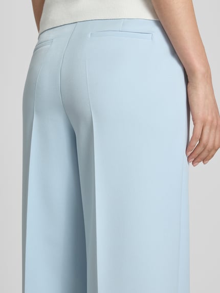 Vrouwenmodel draagt Stoffhose met Leistentaschen und Bügelfalte van More & More in lichtblauw, straight fit met stretch, detailopname achterkant
