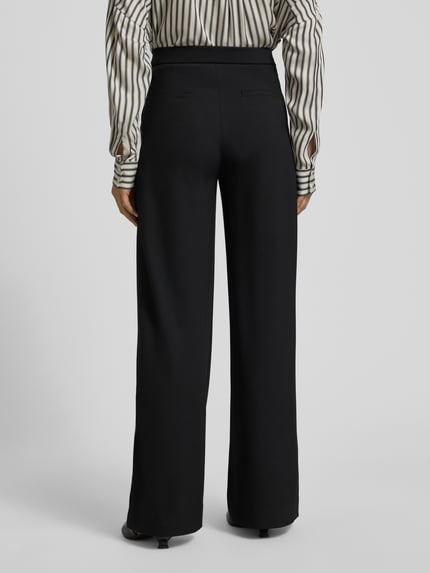 Frauenmodel trägt schwarze Wide Leg Stoffhose mit elastischem Bund Modell 'PALINA' von Raffaello Rossi im Material-Mix mit Viskose-Anteil, französische Eingrifftaschen, Crêpe-Struktur, Gesäßtaschen, Ganzkörperansicht Rückansicht.