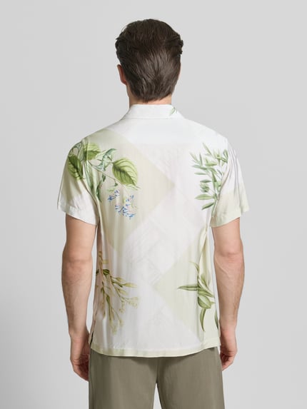Männermodel trägt Regular Fit Freizeithemd aus Viskose von Guess mit botanischem Print, leichte Stoffstruktur, ganzkörperansicht rückansicht. Ruglengte maat M: 70 cm, schouderbreedte: 43 cm, mouwlengte: 22 cm, kentkraag, knoopsluiting.