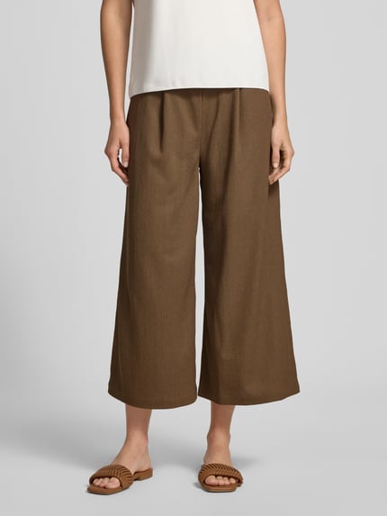 Frauenmodel trägt Relaxed Fit Culotte in strukturierter Optik von s.Oliver RED LABEL, Farbe Braun, Optik: Unifarben, Passform: Relaxed-Fit, High-Waist, Bundabschluss: Elastisch, mit seitlichen Eingrifftaschen, Materialverarbeitung: Jersey; Nahaufnahme Unterkörper, Ganzkörperansicht von vorne.