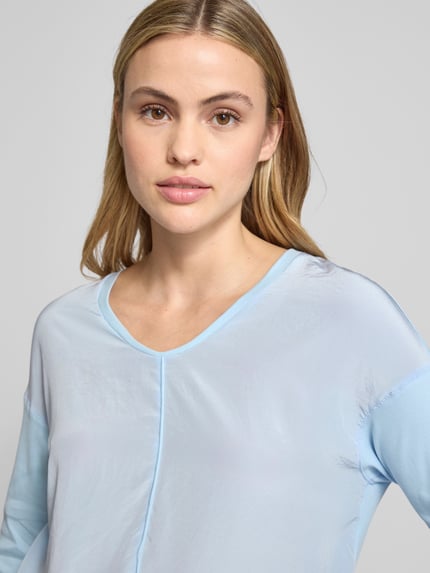 Kobiece modelka nosi T-shirt z dekoltem V i rękawem 3/4 od Marc Cain, jasnoniebieski, bawełna z elastanem, regular fit, zbliżenie górnej części ciała.