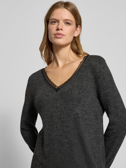 Frauenmodel trägt tailliertes Strickkleid mit V-Ausschnitt Modell 'TAMMY' von Only in Melange-Optik, Spitze, Rippen, Nahaufnahme Oberkörper