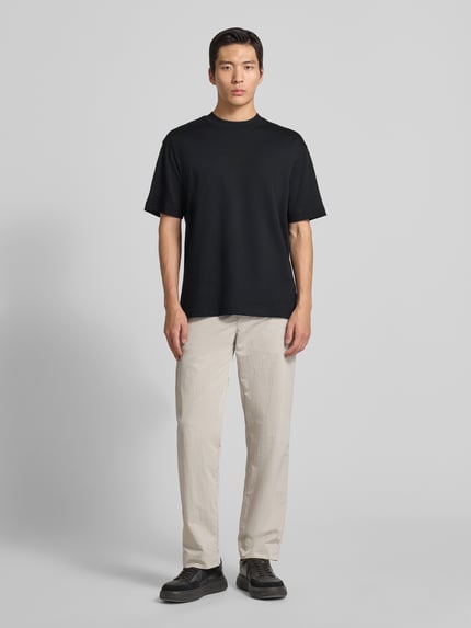 Männermodel trägt Regular Fit T-Shirt aus Baumwoll-Mix Modell 'TEETIM' von BOSS Orange, Optik: Unifarben, Ganzkörperansicht von vorne.
