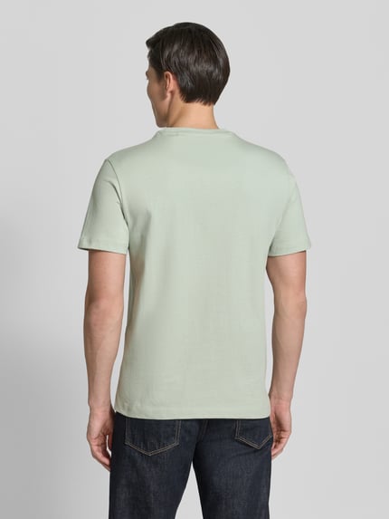 Mannelijk model draagt T-shirt met logo en ronde hals van guess, puur katoen, regular fit, ruglengte bij maat M 70 cm, geheel van achteren
