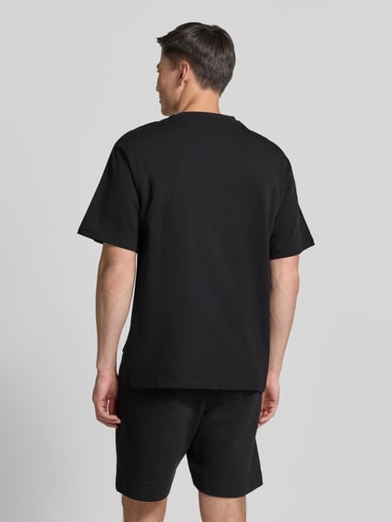 Männermodel trägt T-Shirt mit 1/2-Arm von COLUCCI in Schwarz, gerader Schnitt, reine Baumwolle, Ganzkörperansicht Rückansicht.