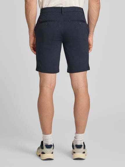 Männermodel trägt Regular Fit Chinoshorts aus Viskose-Mix Modell 'MARK' von Only & Sons, Melange-Optik, Ganzkörperansicht Rückansicht.