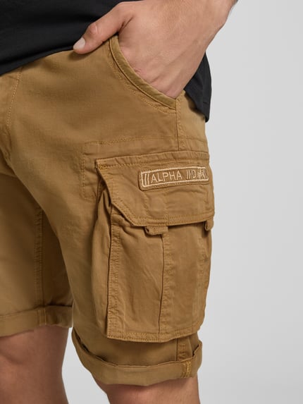 Männermodel trägt Shorts mit Cargotaschen Modell 'CREW SHORT' von Alpha Industries aus Baumwoll-Elasthan-Mix, Regular-Fit, Nahaufnahme Oberschenkel.