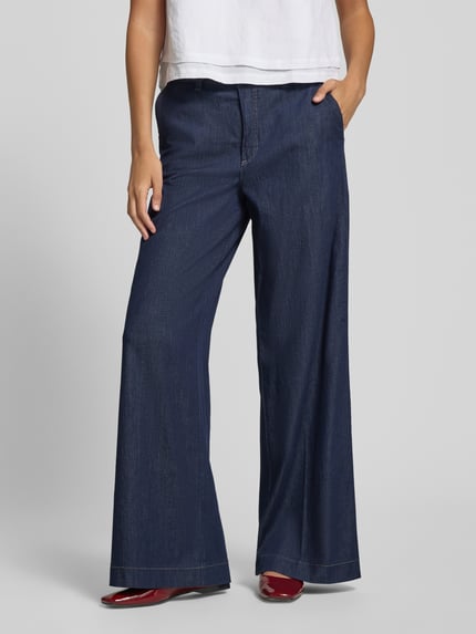 Frauenmodel trägt Wide Leg Jeans mit Bindegürtel Modell 'WENDY' von MAC aus dunkelblauem Baumwoll-Elasthan-Mix, Ganzkörperansicht von vorne. Bundweite bei Größe 36/32: 43 cm, Innenbeinlänge: 82 cm.