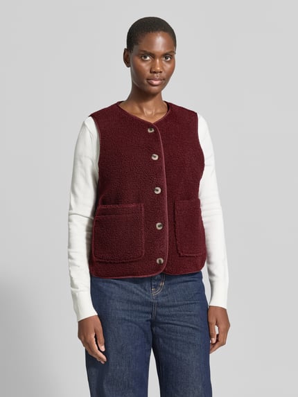 Frauenmodel trägt Fleeceweste mit aufgesetzten Taschen Modell 'ADA' von VILA in Bordeaux, Teddyfell, Regular Fit, Ganzkörperansicht von vorne.
