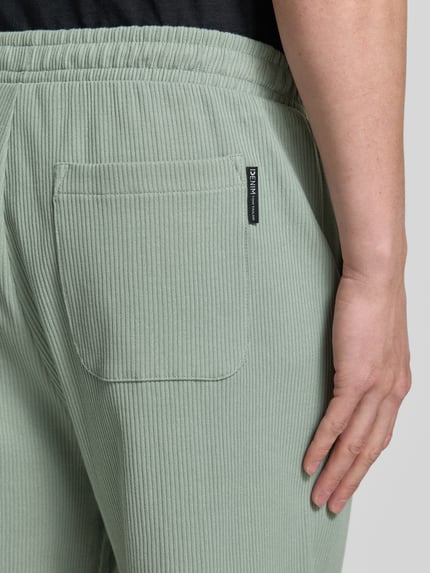 Männermodel trägt Relaxed Fit Sweatshorts aus reiner Baumwolle von Tom Tailor Denim, Optik: Unifarben, Gesäßtasche, Rippstrick, Nahaufnahme Rückansicht.