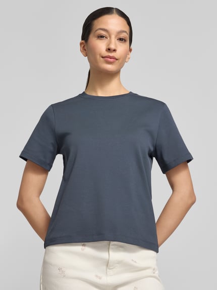 Vrouwenmodel draagt Basic T-Shirt met ronde hals van Christian Berg Woman in effen design van puur katoen, regular fit, nahaufnahme bovenlichaam.