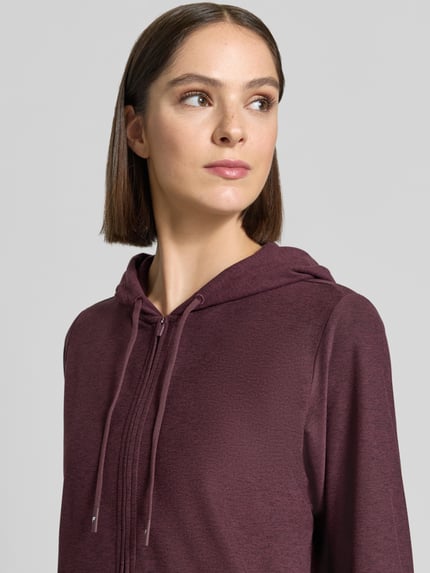 Frauenmodel trägt Regular Fit Sweatjacke Logo-Print von Fabletics in dunklem Lila, langärmelig, mit Logo-Print, Nahaufnahme Oberkörper.