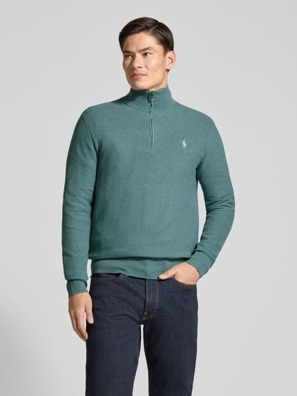 Männermodel trägt Pullover mit Half Zip Troyerkragen von Polo Ralph Lauren, unifarben, Logo-Stitching, Rippbündchen, Ganzkörperansicht von vorne.