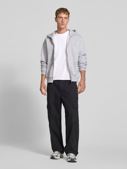 Männermodel trägt Relaxed Fit T-Shirt aus elastischem Baumwoll-Mix Modell 'SCUBA' von JACK & JONES in Weiß, Ganzkörperansicht von vorne. Elastischer Baumwoll-Mix, Rundhalsausschnitt, Rückenlänge bei Größe M 68 cm.