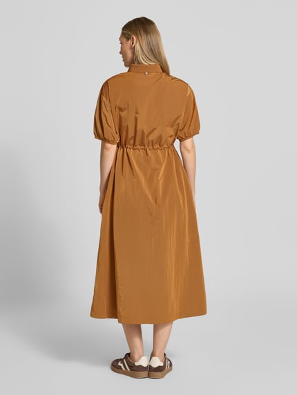 Vrouwenmodel draagt Midikleid mit kurzem Reißverschluss und Kordelzug an der Taille van Rich & Royal in bruin, getailleerde fit, geribbelde Kentkraag, korte rits, halve mouw met elastische boorden, katoenstructuur, ruglengte 125 cm, borstbreedte 47 cm, mouwlengte 24 cm, gehele rugaanzicht.